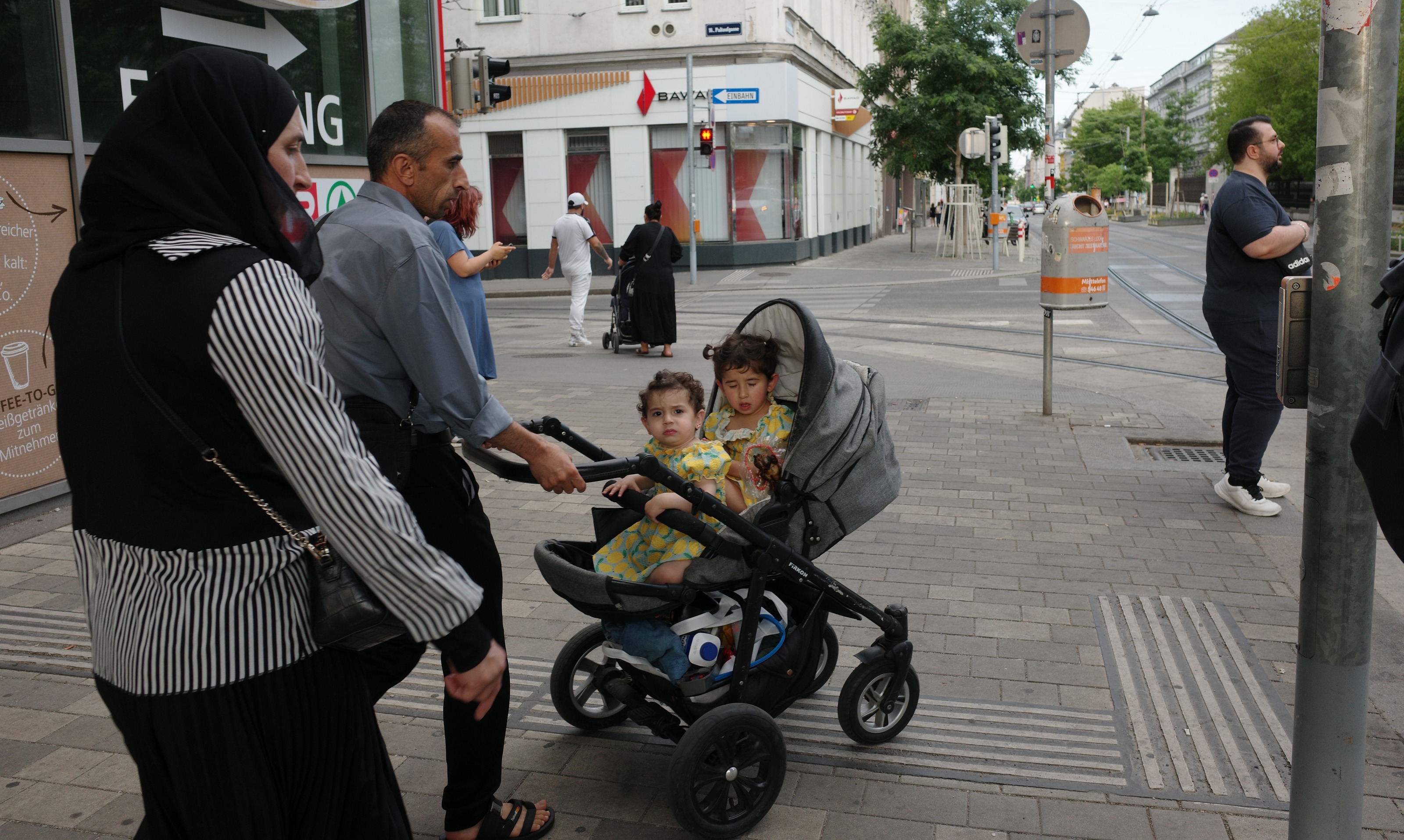 A family with a stroller waiting at a crossing